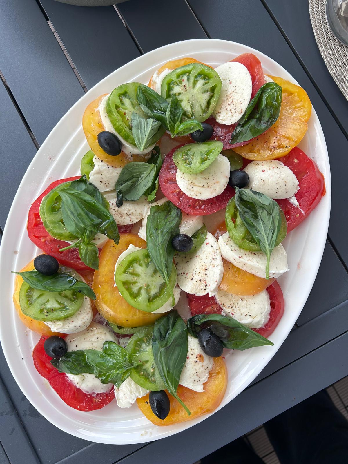 Salade méditerranéenne de tomates colorées, mozzarella, basilic frais et olives — alimentation gourmande et équilibrée